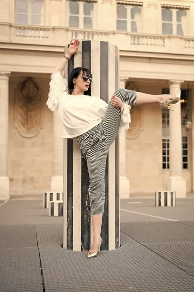 Donna sensuale con i capelli castani. Bellezza ragazza con look glamour. Modella in occhiali da sole su quadrato. Moda e moda. Yoga e concetto di sport. Donna posa su scarpe con tacco alto a Parigi, Francia — Foto Stock