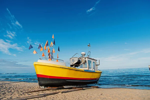 Boat on sand beach in Gdansk, Poland. Small ship on sea shore on blue sky. Vessel and water transport. Summer vacation and sea travel. Wanderlust with adventure and discovery — Stock Photo, Image