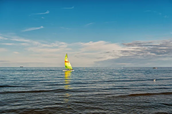 Sailing boat in sea of Gdansk, Poland. Sailboat with bright sail sailing on water on blue sky. Summer adventure and active vacation. Yacht sailing and wanderlust. Vessel and water transport — Stock Photo, Image