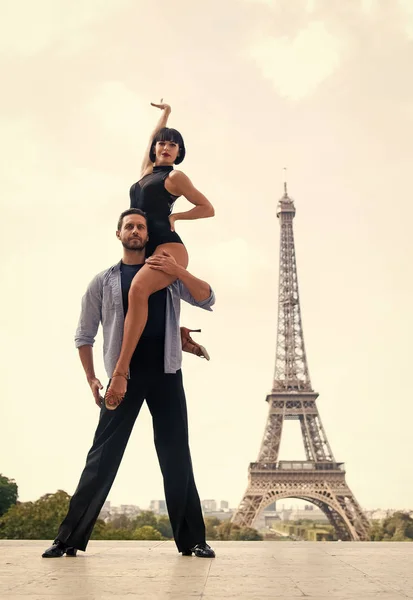 dance couple in front of eifel tower in paris, france. beatuiful ballroom dance couple in dance pose near eifel tower. romantic travel concept