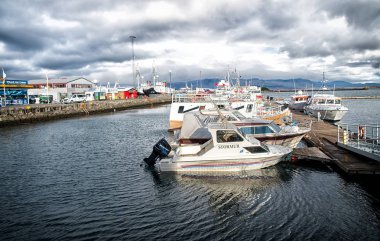 Reykjavik, İzlanda - 13 Ekim 2017: Motorlu kayak sandallar küçük köyde deniz iskelede. Bulutlu gökyüzü deniz kıyısında, yatlar. Su ulaştırma araçları ve tekne ile seyahat. Tatil veya Yolculuk tutkusu ve seyahat.