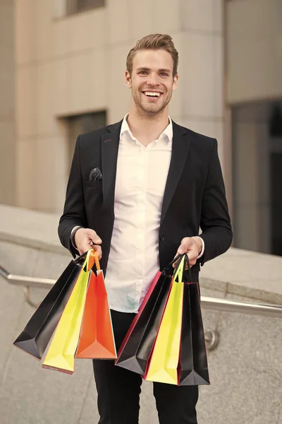 Man stylist professional shopper. Clothes courier. Stylist buy fashionable clothes client. Shopping service concept. Man formal suit shopping mall. Shop assistant helps carries bunch shopping bags