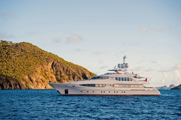 Jacht na morzu wybrzeża na słoneczny błękitne niebo w gustavia, st.barts. Jachting i żeglarstwo przygoda. Luxury travel oraz rejs na statku. Wakacje na tropikalnej wyspie. Transportu i handlu morskiego statku wody — Zdjęcie stockowe