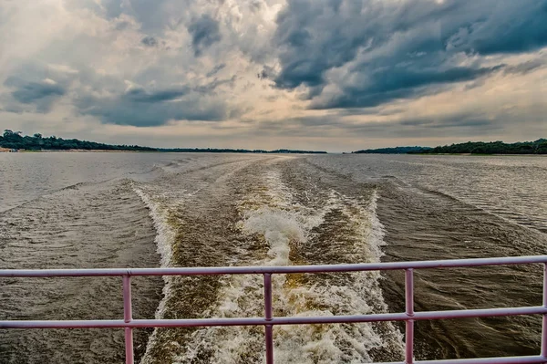 Speed and energy concept. Trace on water in blue sea in manaus, brazil. Sea coast on horizon on cloudy sky. Wanderlust discovery and adventure. Travelling by water — Stock Photo, Image