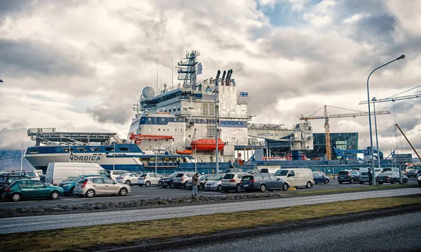 Ρέικιαβικ, Ισλανδία - 13 Οκτωβρίου 2017: αυτοκίνητα και πλοίο στο συννεφιασμένο ουρανό. Κίνηση στο δρόμο και σκάφους στο λιμάνι. Μεταφορών και τη μεταφορά. Ταξίδι ή εκδρομή και περιπλάνησης — Φωτογραφία Αρχείου
