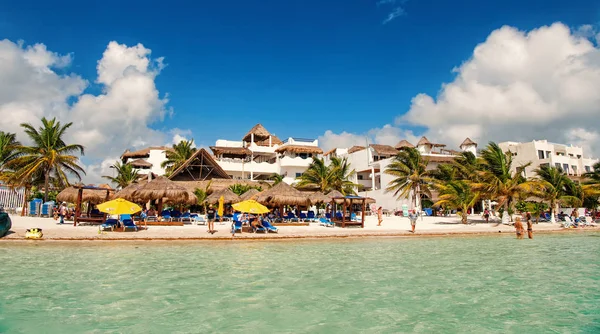 Тропический пляж в Коста-Майе, Мексика. Морская или океанская вода с людьми и зонтиками на песке. Отель и зеленые пальмы на солнечном голубом небе. Летние каникулы в тропиках. Путешествия и приключения — стоковое фото