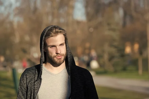 Modemann in stylischer Sportbekleidung. Macho mit Bart und Kapuze an einem sonnigen Tag. Der bärtige Mann trägt lässiges Sweatshirt im Freien. Lebensstil für aktive und gesunde Menschen. Sportkonzept — Stockfoto