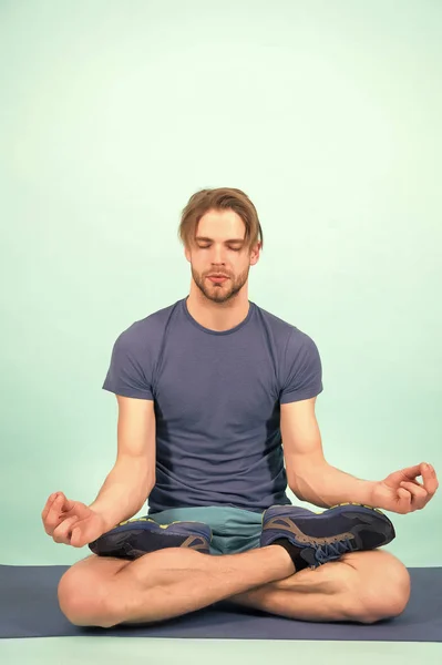 Adam yoga minderi üzerinde meditasyon yapıyor. Sporcu, Lotus pozunda rahatla. Moda sporcusu jimnastik salonunda yoga yapıyor. Beden ve zihin sağlığı için meditasyon. Meditasyon ya da zen ve barış kavramı — Stok fotoğraf