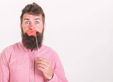 Pembe gömlekli beyaz arka plan üzerinde izole şık sakallı hippi. Doğum günü partisi yakışıklı sakallı adam, kutlama kavramı. Sakallı adam şaşırmış bakışla kadın dudaklar kağıttan yapılmış holding