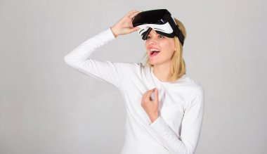Genç kadın bir sanal gerçeklik kulaklık kullanarak. Genç kadın Vr deneyimi sırasında hava dokunmadan hayran. Onun sanal gerçeklik kulaklık ayarlama ve gülümseyen kendine güvenen genç kadın.