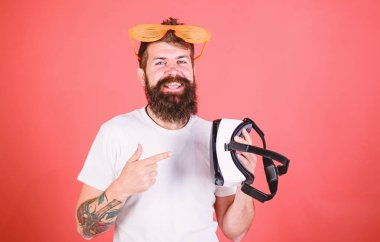 Sakallı adam hippi sanal gerçeklik kulaklık ve çok güneş gözlüğü kırmızı arka plan ile. Alternatif gerçeklik. Hangi gözlük louvered veya sanal seçin. Adam ne tercih gerçek veya sanal karar