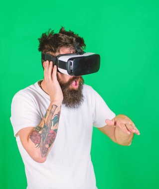 DJ trendy sakal ve dövme yeni gösterisi, müzik ve yaratıcılık kavramı üzerinde çalışan ile. Sanal pikap raylara karıştırma şık sakallı adam. Yeşil arka plan üzerinde izole Vr kulaklık sakallı adam