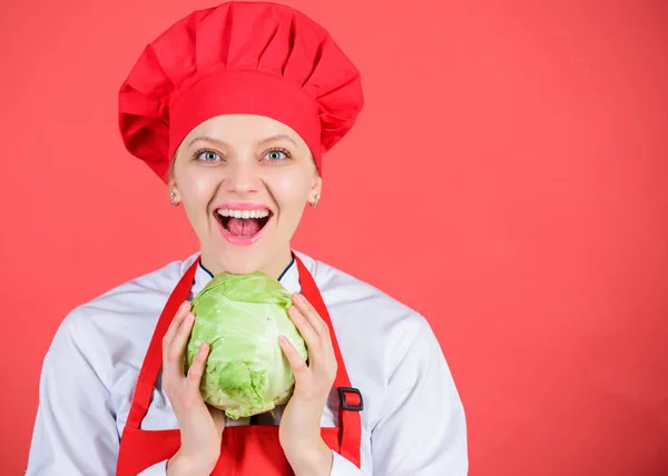 Eat healthy. Dieting concept. Girl wear hat and apron hold vegetable. Healthy nutrition. Woman professional chef hold whole cabbage vegetable. Healthy vegetarian recipe ingredient. Healthy raw food