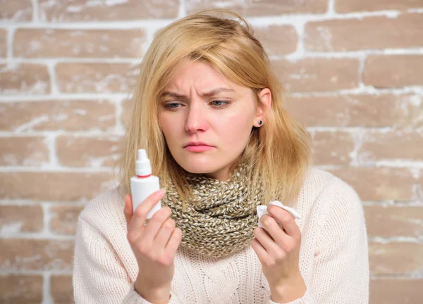 Allergy concept. Home treatment. Effective nasal spray. Runny nose and other symptoms of cold. Nasal drops plastic bottle. Nasal spray runny nose remedy. Girl sick person hold nasal drops and tissue — Stock Photo, Image