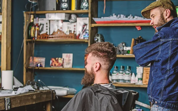 Kunden- und professionelle Meisterprüfung Ergebnis oder Haarschnitt. Hipster-Klient bekam neuen Haarschnitt. Friseur mit bärtigem Mann, der in den Spiegel schaut, Barbershop-Hintergrund. Haarschnitt-Konzept. Friseur fertig gestylt — Stockfoto