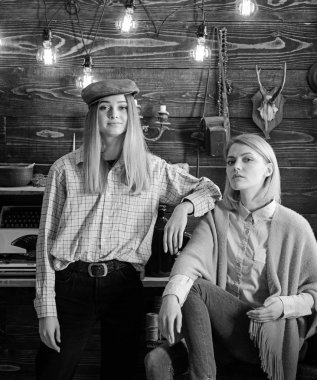 Arkadaş veya kız kardeşim hoş gamekeepers evde, iç arka plan akşamın. Kızlar sakin yüzler üzerinde dinlenme yaparken sıcak atmosferinin keyfini çıkarın. Ormanda kavramı tatil. Kızlar iyi tatiller