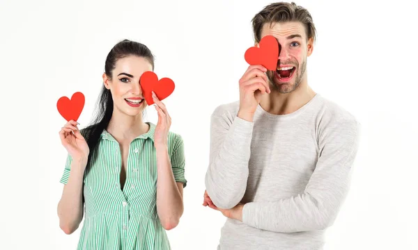 Hombre y mujer pareja en el amor tienen tarjetas de San Valentín corazón rojo sobre fondo blanco. Una pareja romántica enamorada. Concepto de sentimientos románticos. Día de San Valentín y amor. Hombre guapo y chica guapa enamorada — Foto de Stock