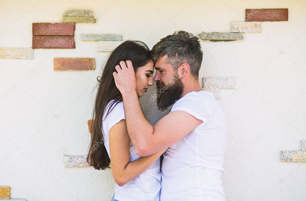 Couple in love enjoy each other romantic date. Man bearded and girl hugs or cuddling. Tender hug. Couple in love romantic date cuddling outdoors light wall background. So good to feel your hug