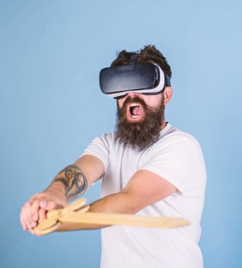VR oyun kavramı. Vr gözlük, açık mavi renkli sakallı adam. Hipster yüz bağırarak üzerinde sanal gerçeklik oyun oyun keyfini çıkarın. Adam ile kafa monte göstermek ve kılıç oyun Vr oyun mücadele
