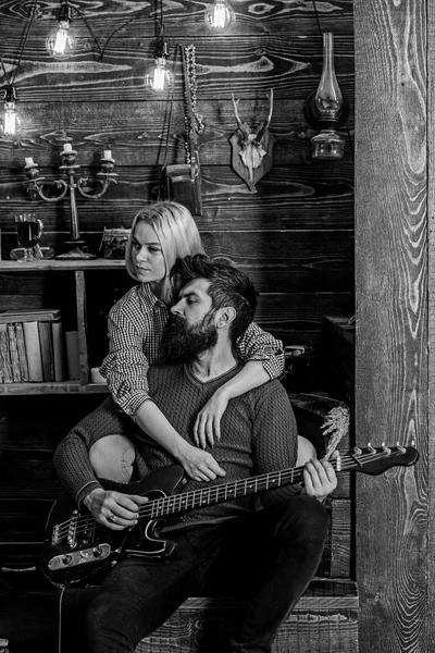 Çift ahşap vintage iç gitar müziğin tadını çıkarın. Bayan ve rüya gibi yüzleri sakallı hugs ve gitar çalıyor. Aşık çift sıcak atmosferde romantik akşamın. Romantik akşam kavramı — Stok fotoğraf