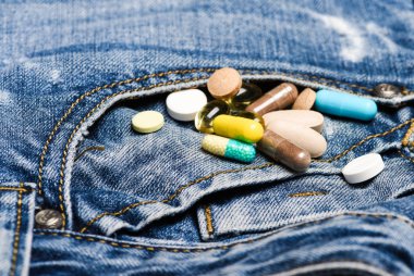 Uyuşturucu denim arka plan üzerinde. İlaçlar karıştırma. Hızlı tedavi. İlaç reçete. Sağlık ve hastalık. Doz ve bağımlılığı. Uyuşturucu bağımlılığı. Renkli hapları kümesi. İlaç ve tedavi kavramı