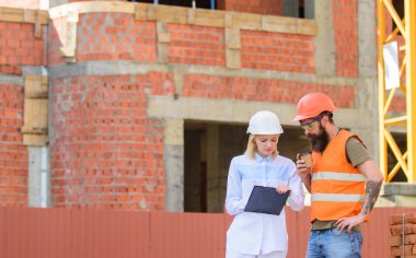 İnşaat ekibi iletişim kavramı. Kadın mühendis ve Oluşturucu inşaat alanında iletişim. İlerleme planı tartışmak. İnşaat sektöründe katılımcı ve inşaat istemciler arasındaki ilişkileri