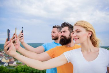 Selfie sosyal ağ paylaşımı. En iyi kameralı cep telefonu ile selfie alarak arkadaşlar. Güzel kadın ve erkekler akıllı telefonlar elinde tutan. İnsanlar doğa üzerinde çekim selfie tadını çıkarın. Kendini ifade biçimi