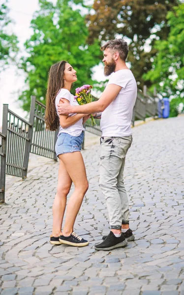 Guy bereid verrassing boeket voor vriendin. Romantische datum wandeling. Gentlemans manieren. Man geeft bloemboeket meisje romantische toe. Bijeenkomst voor datum park achtergrond (echt) paar. Boeket altijd goed idee — Stockfoto