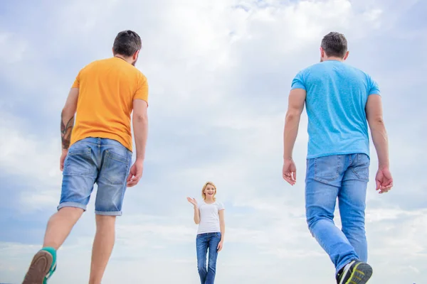 Estate fresca e brigh. Bella donna e gli amici uomini a piedi all'aperto. Le persone di moda sembrano casual in abito estivo. Gruppo di persone in abbigliamento casual. Giovani in stile casual su cielo nuvoloso — Foto Stock