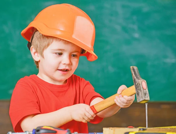 Lustiger Junge hämmert Nagel. Kind probiert neue Fertigkeiten aus. individuelles Lernkonzept — Stockfoto