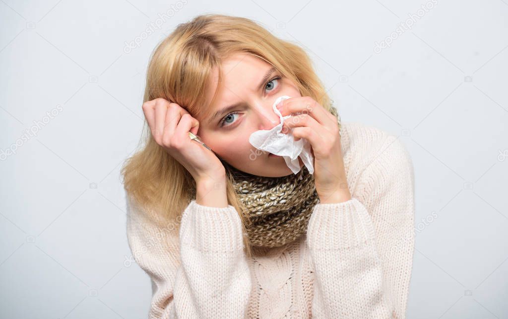 How to bring fever down. Girl sick hold thermometer and tissue. Measure temperature. Break fever remedies. Seasonal flu concept. Woman feels badly. Fever symptoms and causes. Sick girl with fever