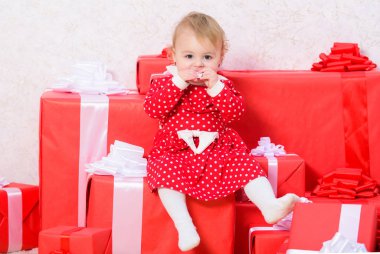 Noel'de küçük çocuklar ile yapılacak işler. Yürümeye başlayan çocuk için Noel hediyeleri. Çocuk için ilk hediyeler Noel. İlk Noel kutlaması. Küçük kız bebek hediye kutuları yığını oynamak. Aile tatilleri