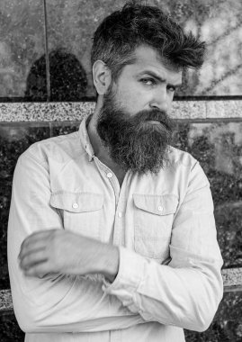 Erkeklik kavramı. Adam şüpheli görünüyor. Tousled saçlı hippi tutun kollar göğüs üzerinde geçti. Sakal ve bıyık düşünceli, dalgın yüzünde siyah mermer zemin üzerine olan adam