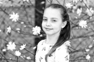 Açık havada çiçek açan bir çocuk. Baharda çiçek açan küçük bir kız. Taze görünüşlü ve uzun saçlı güzel bir çocuk. Bahar, Paskalya ve bayram kutlaması konsepti