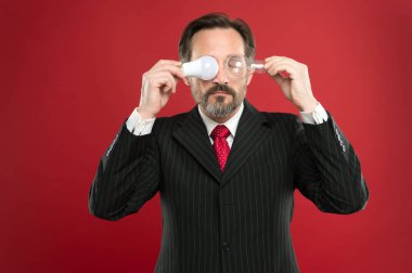 Yaratıcı fikir üretmek. Güç tasarrufu. karışık erkek iş kıyafeti. Takım elbise tutun ampul'iş adamıdır. Elektrik ve enerji. Sakal arama ilham için olan adam. Olgun sakallı adam