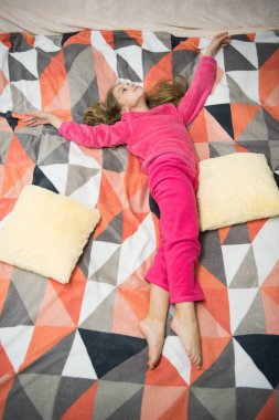 Kız küçük çocuk giyim yumuşak şirin pijama yatakta dinlenirken. Yorgun bebek rahatlatıcı. Pijama ve ev için giyim. Pijama ve yatak Tekstil. Çocuk eğlence keyfini çıkarın. Relax için rahat pijama