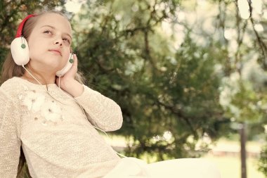 Güzel küçük kız kulaklıkla müzik dinlemekten hoşlanıyor.