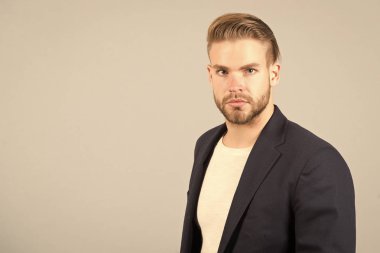 Adam çekici bakımlı işadamı sakallı. Sakal tıraşsız adam adam yakışıklı bakımlı formal giyim görünüyor. Moda kavramı. İşadamı sıkı sakin yüz Yöneticisi, gri arka plan sakallı