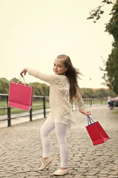 Menina bonito andando com os sacos de compras rosa — Fotografia de Stock