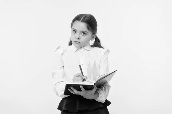 Девушка милая школьница в форме держать книгу с информацией желтого фона. Ученик получает информацию из книги. Школьная форма для детей подготовиться к уроку информации. Заметная информация — стоковое фото