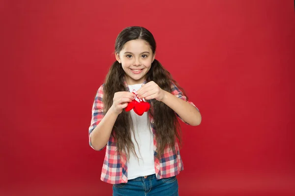 Mothers day holiday. Tradition celebrate valentines day. Sincere love. Be my valentine. Family love. Girl cute child with hearts. Kid girl with long hair red background. Celebrate valentines day