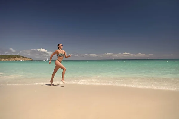 Девушка в сексуальном купальнике бегает по пляжу — стоковое фото