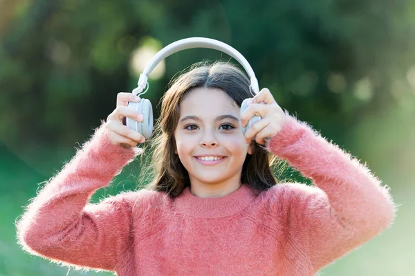 Ela só quer ouvir música. Menina adorável ao ar livre. Menina criança usando fones de ouvido. Criança feliz gosta de ouvir música em movimento. Ter um som incrível para todo o seu entretenimento — Fotografia de Stock