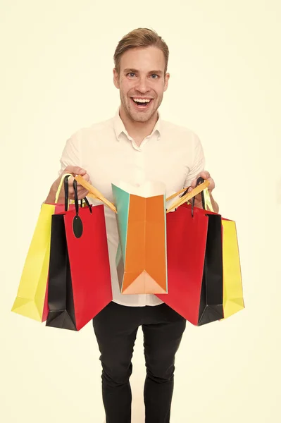 Man happy client received packages purchases. Delivery service. Guy buy fashionable clothes online. Online shopping concept. Man takes advantages online shopping. Guy carries bunch colorful bags