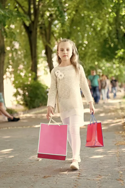 Menina bonito andando com os sacos de compras rosa — Fotografia de Stock
