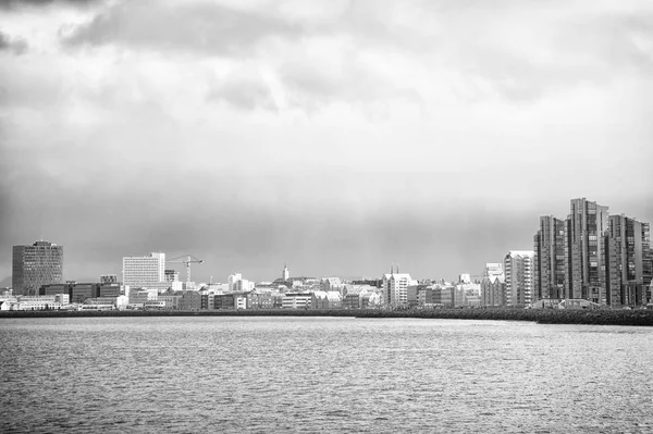 Reykjavík přímořská pláň dramatické oblačné nebe. Město na mořském pobřeží Island. Skandinávská koncepce přímořských oblastí. Klidná vodní plocha a město s vysokými budovami moderní architektury. Skandinávské město na pobřeží — Stock fotografie