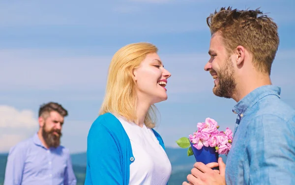 Nouvel amour. Ex partenaire regarder fille commence relations amoureuses heureuses. Ex mari jaloux sur fond. Couple amoureux sortir ensemble journée ensoleillée en plein air, fond du ciel. Couple avec bouquet de fleurs date romantique — Photo