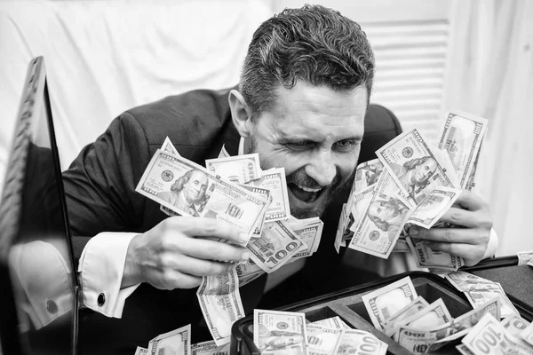 Portrait of a happy young businessman throwing money banknotes. Businessman with money on office room. Money in business. Illegal money profit concept.