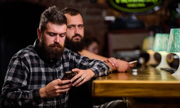 Order drinks at bar counter. Men with smartphone relaxing at bar. Mobile dependence concept. Mobile phone always with me. Friday relaxation in bar. Hipster bearded man spend leisure at bar counter — Stock Photo, Image