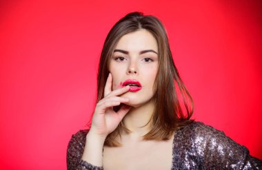Makyaj ve kozmetik konsepti. Güzellik ipuçları. Kırmızı arka planda poz veren kız makyajı dudakları. Parti için makyaj. Mükemmel makyaj için dirençli ürünler. Dayanıklı ruj. Bozuk makyajlı kadın